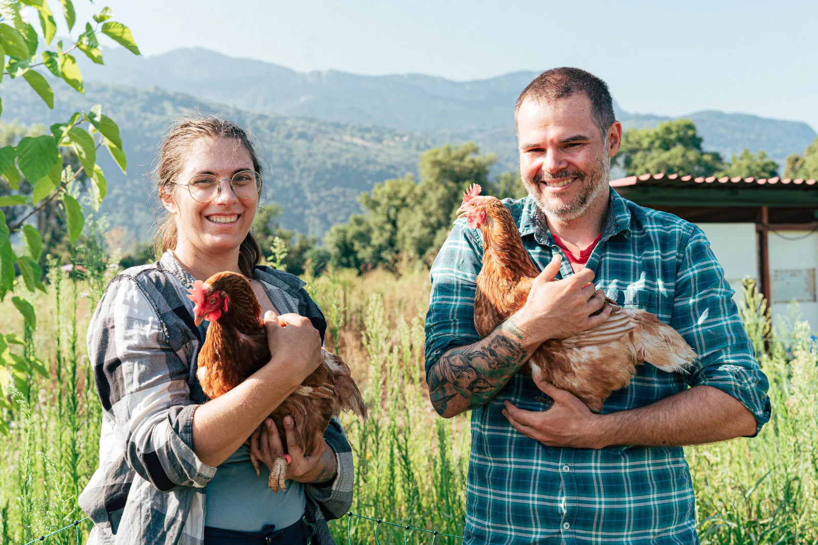 Alix et Alex les deux propriétaires de la ferme portant chacun une poule